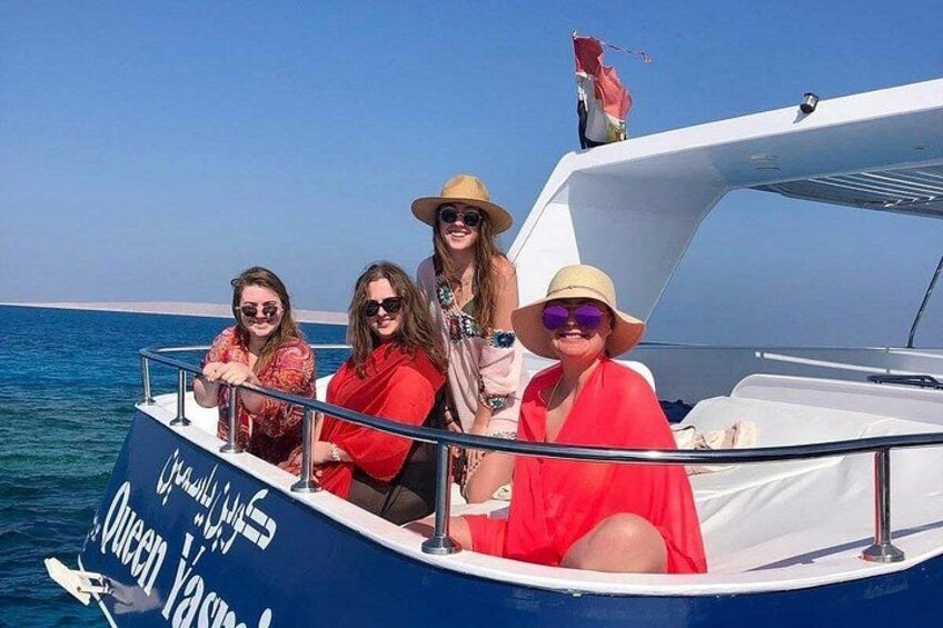 A group of people on a boat with a clear blue sky and calm sea in the background. 4