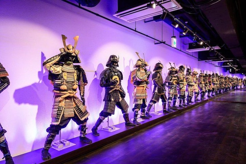 A museum exhibit with a row of samurai armor displays. 2