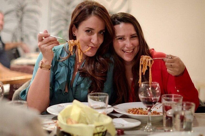 Two people dining at a restaurant with plates of food and glasses of water. 2