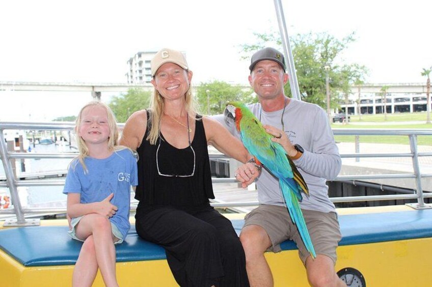 Three people on a boat with a parrot. 2