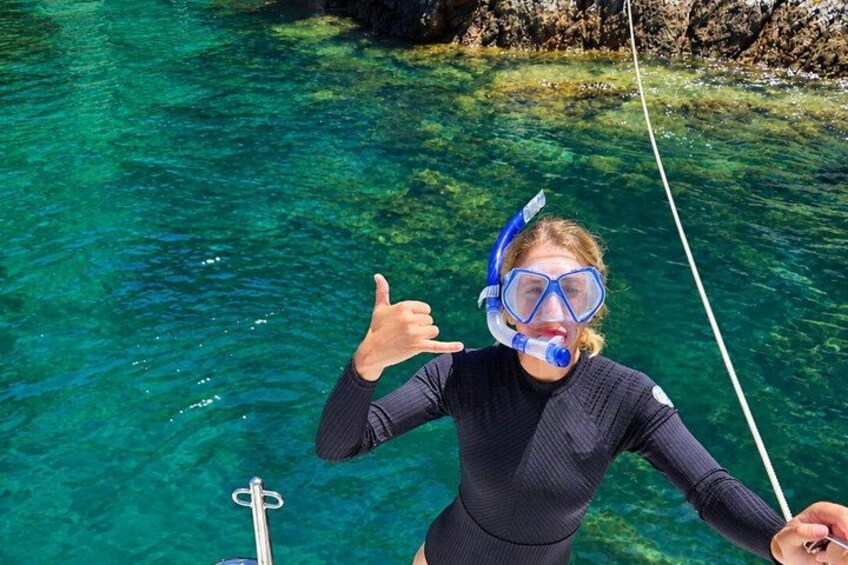 En person snorkler i klart, blåt vand og holder fast i en rebe. 2