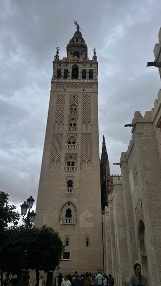 A tall tower with intricate architectural details and a statue on top. 2