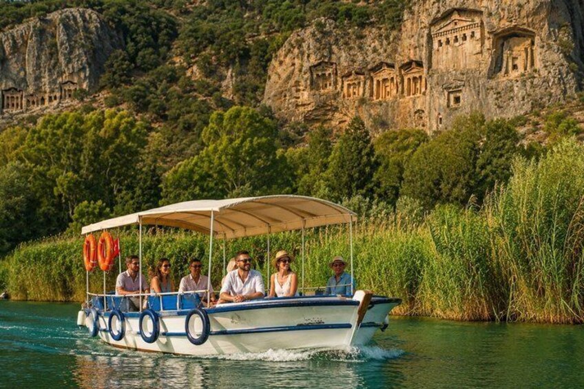 A boat with passengers on a river, surrounded by greenery and ancient ruins. 3