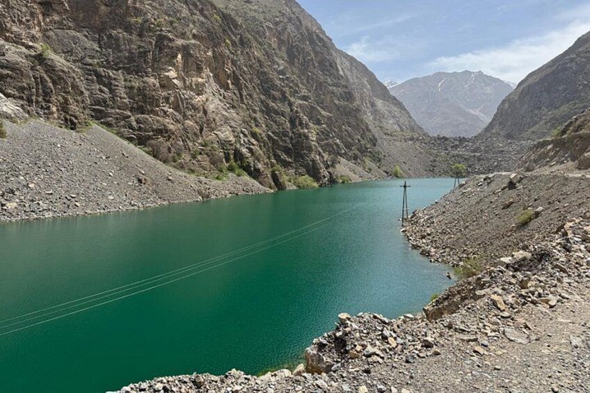 Un lac verdoyant, entouré de montagnes rocheuses. 4