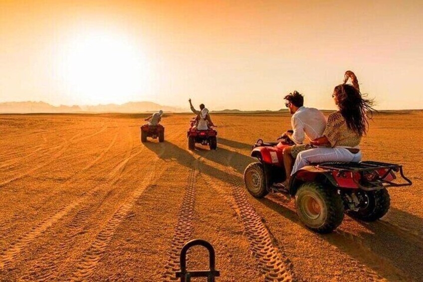 Un paysage désertique où l’on voit des personnes conduisant des quads. 1