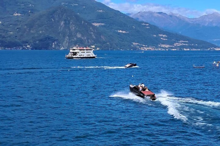 A boat speeding across a lake with mountains in the background. 4