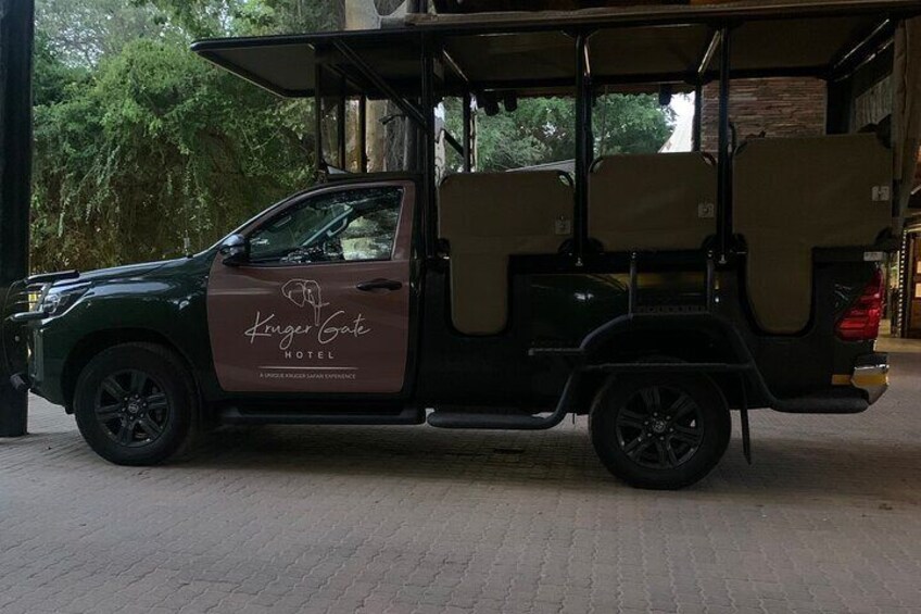 A golf cart with the text "King Gate Hotel" on its side parked in front of a building. 1