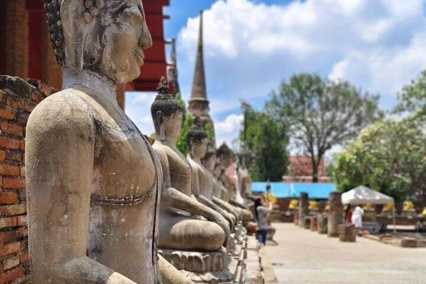 Una hilera de estatuas de Buda de piedra en un entorno exterior. 4