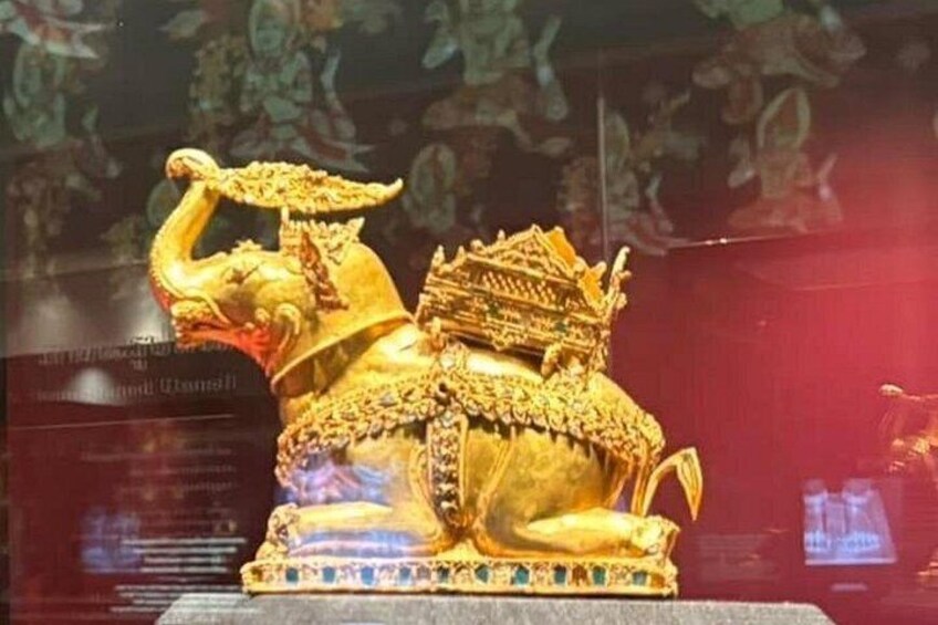 Una estatua dorada de una deidad sobre un león, adornada con joyas intrincadas y una corona. 2