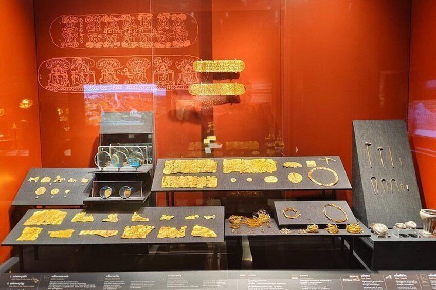 Una vitrina de joyería con diversas piezas sobre pedestales negros, incluyendo anillos, pulseras y collares. 5
