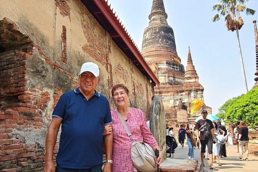 Una pareja de pie frente a un templo histórico, con una gran estupa al fondo. 3
