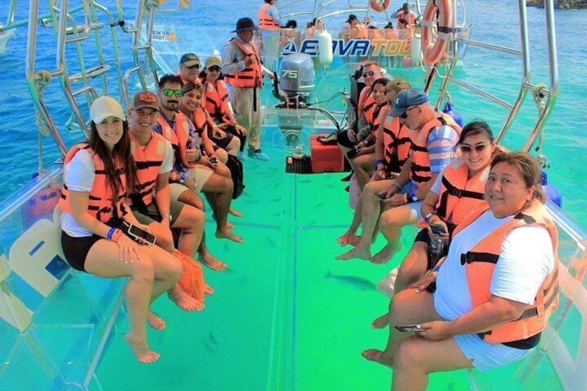 Un groupe de personnes à bord d’un bateau, portant des gilets de sauvetage, avec une mer bleue et limpide en arrière-plan. 4
