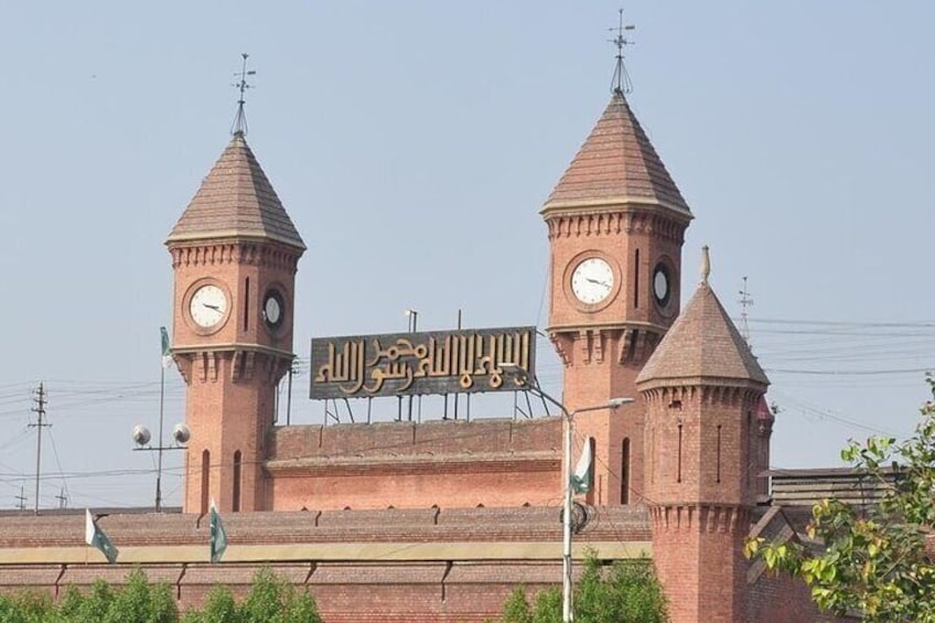 En historisk byggnad med två klocktorn och en skylt på arabiska. 4