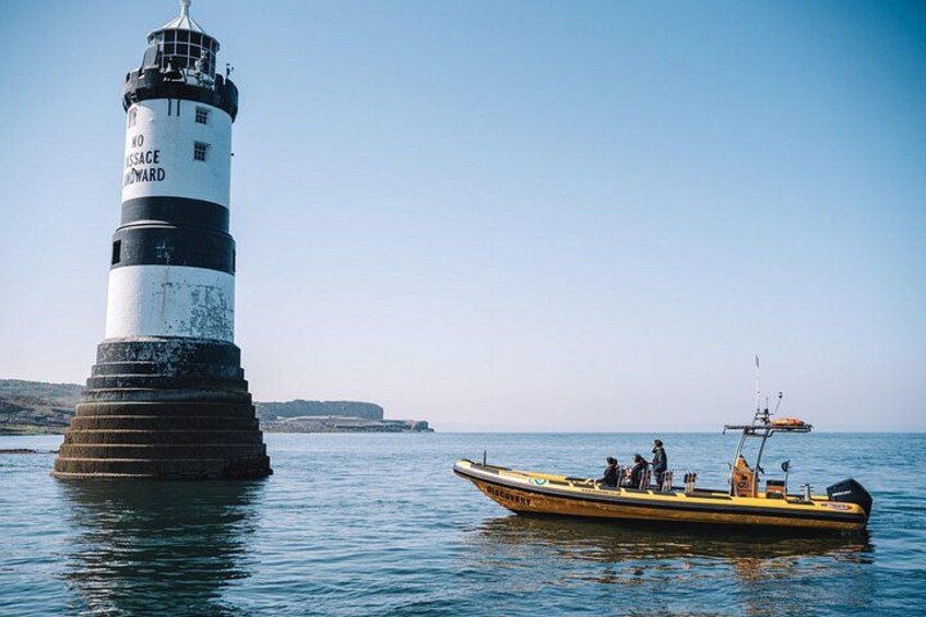 Een vuurtoren, een boot en rustig water. 4