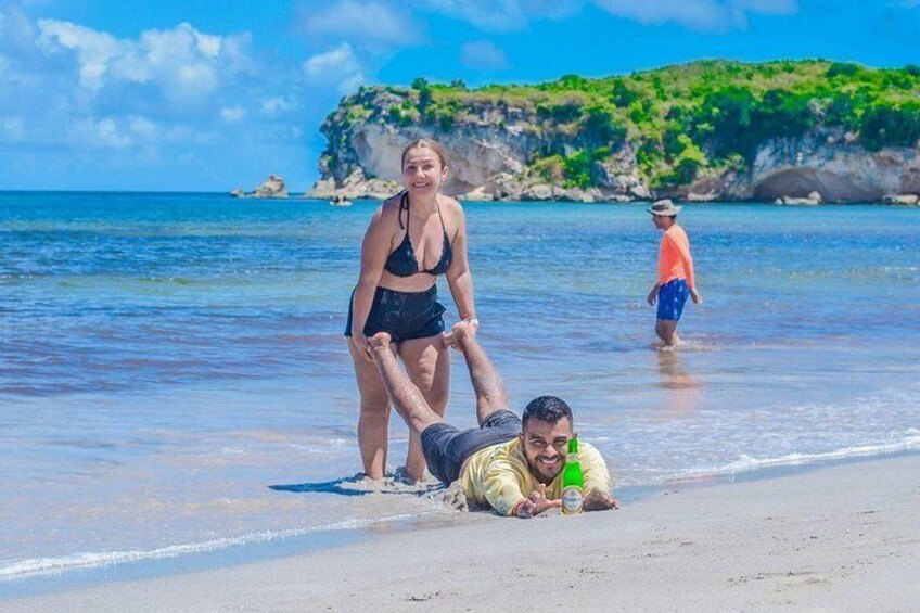 A beach scene with a person lying on the sand, another person standing, and a child in the background. 5