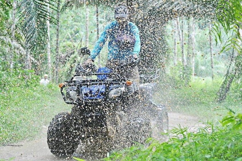 A person riding a quad bike through a forested area. 2