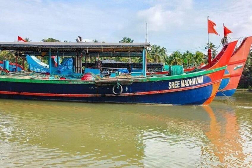 Un bote colorido llamado 'Sree Madhavam' con cubierta y bandera. 3