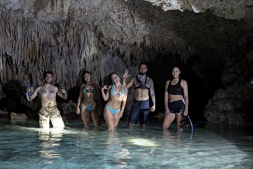 A group of people in a cave with water at the bottom. 5