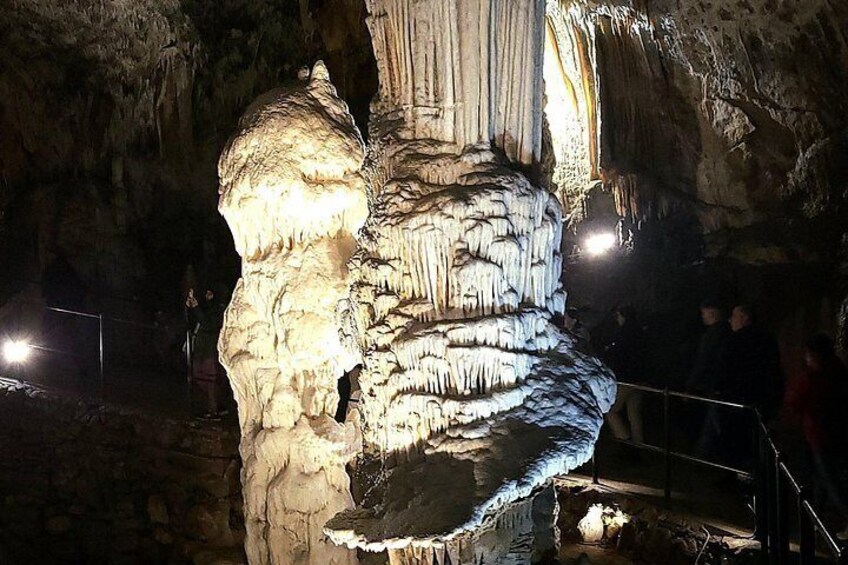 A large, illuminated cave formation with stalactites and stalagmites. 2