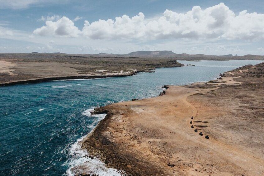 Un paysage côtier avec un ciel dégagé, une plage de sable et une étendue d’eau. 5