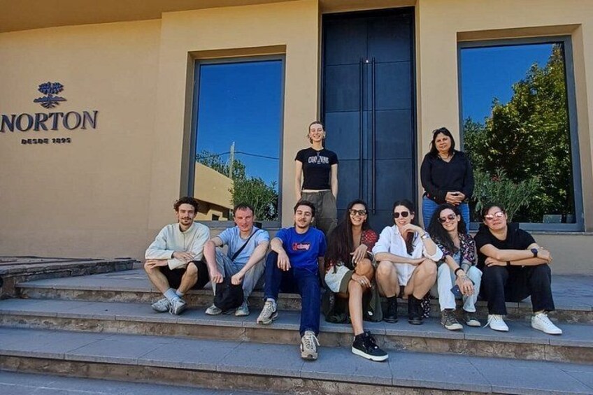 Un grupo de personas sentadas en escalones frente a un edificio con un letrero que dice 'NORTON'. 2