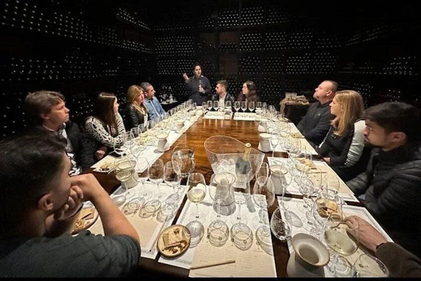 Una cena formal con una larga mesa, copas de vino y platos. 5