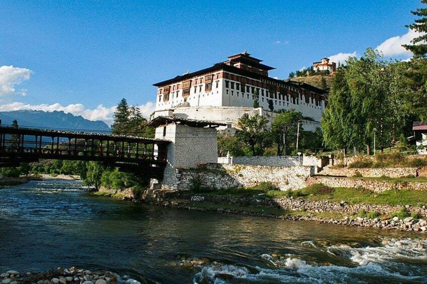A traditional building by a river with a bridge in the foreground. 3
