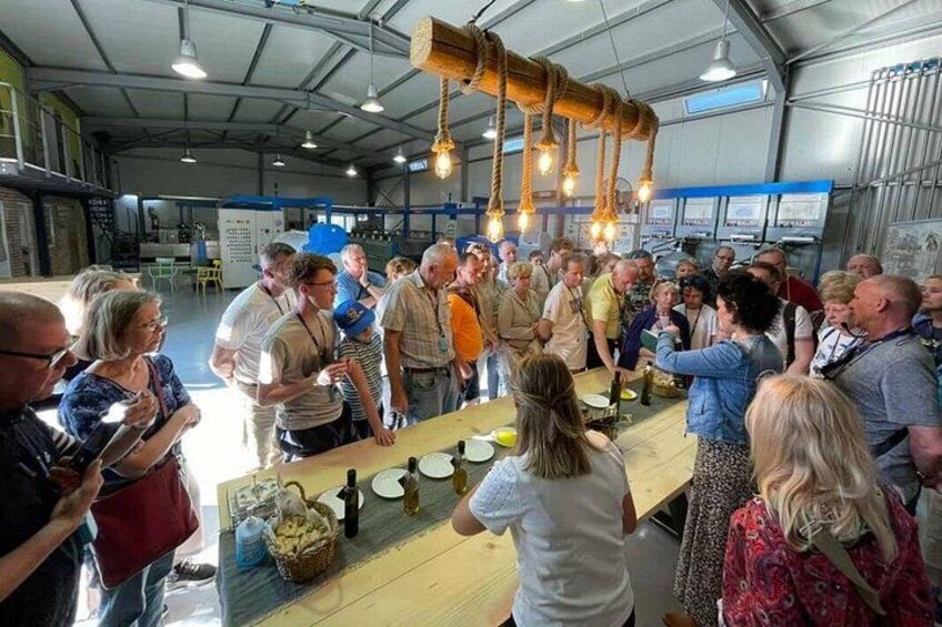 Un groupe de personnes s’est réuni autour d’une table où étaient disposées des bouteilles et des verres, probablement dans le cadre d’une dégustation ou d’une activité éducative. 2