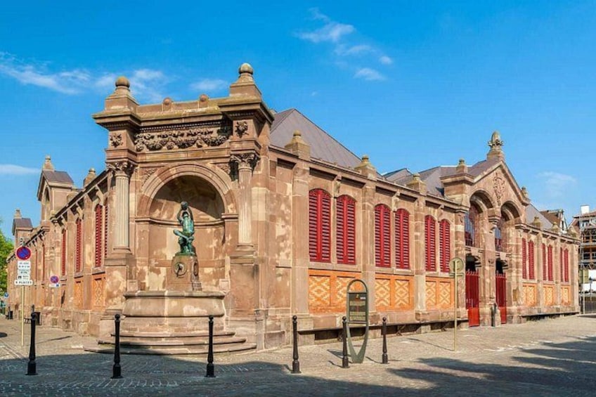 A historic building with ornate architecture, a statue in front, and a clear blue sky. 5