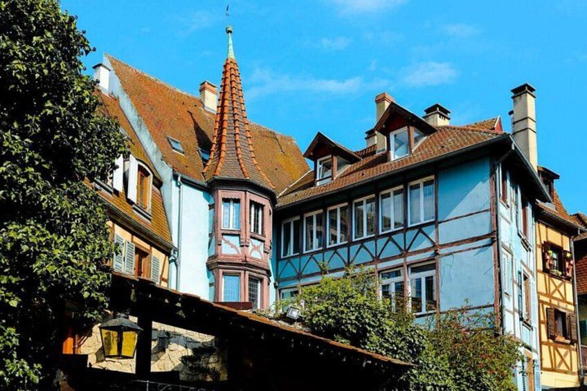 A traditional European town with colorful buildings, a prominent tower, and a bridge. 3