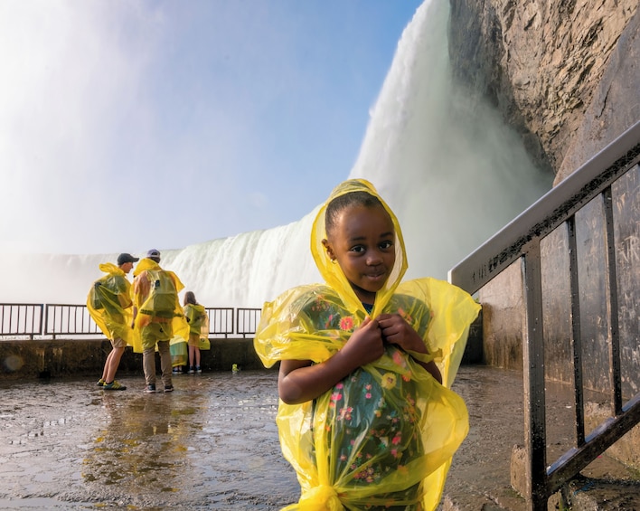 Een waterval met mensen in gele regenponcho's. 2