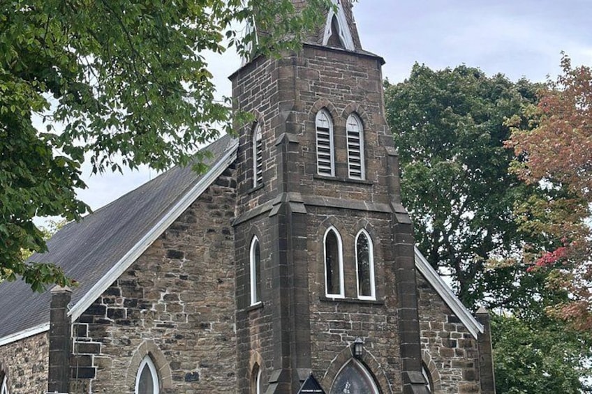 Une église en pierre dotée d’un clocher et de fenêtres en arc. 3