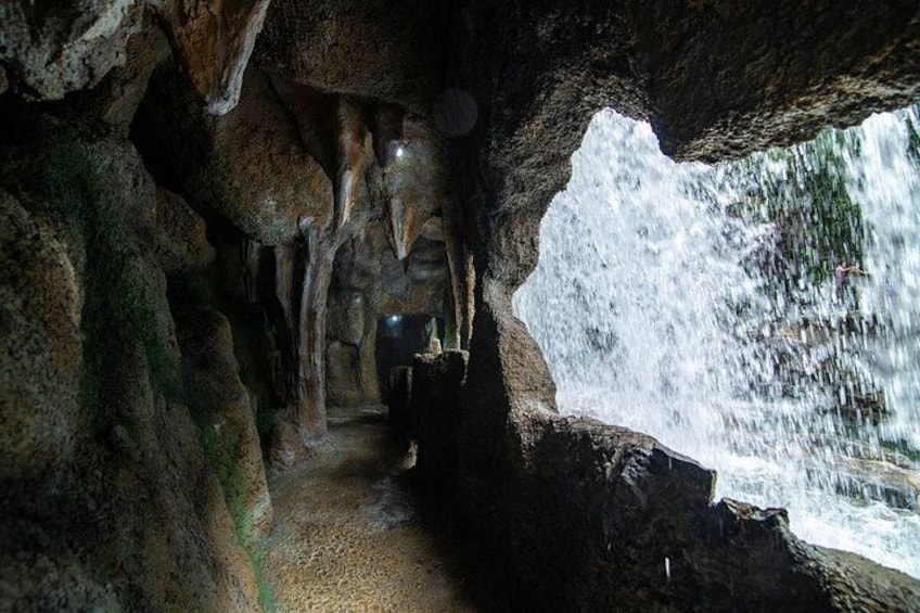A cave with stalactites and a waterfall. 3