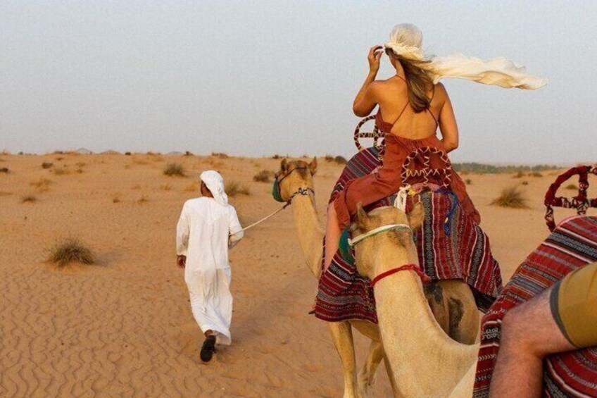 A person riding a camel in a desert landscape. 4