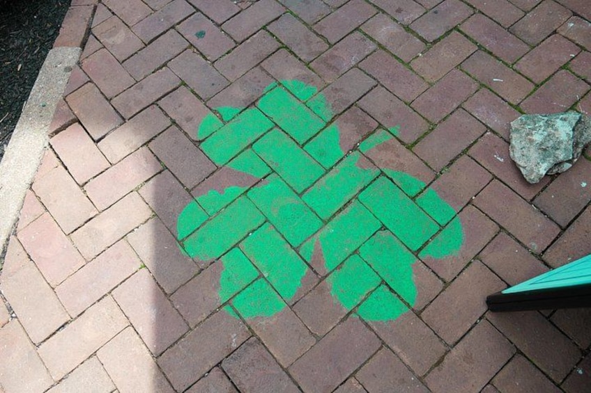 A brick pavement with a green shamrock painted on it. 4