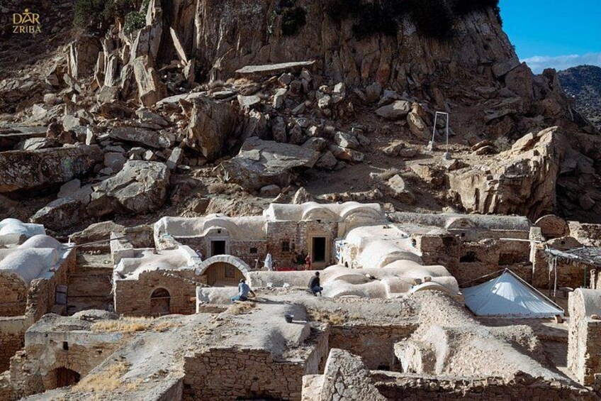 Ancient ruins with stone structures and a rocky landscape. 5
