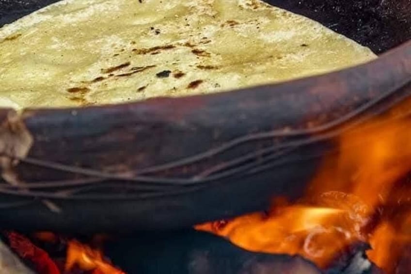 A flatbread being cooked over an open flame. 2