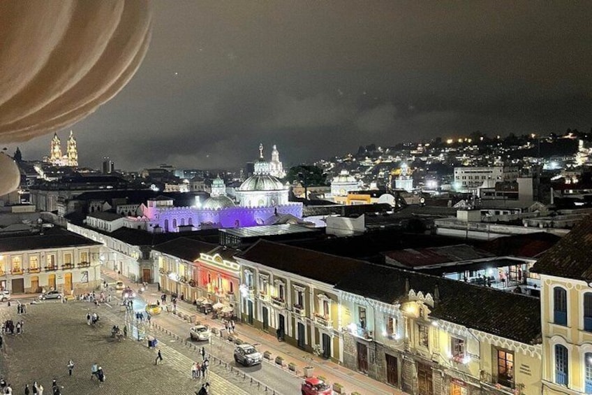 A cityscape at night with illuminated buildings and a prominent church dome. 3