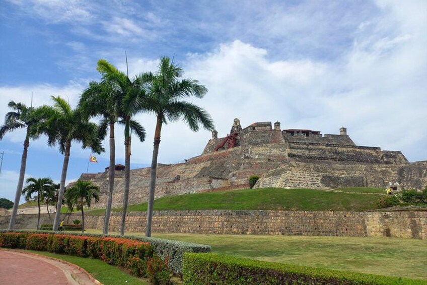 A historic fort with palm trees and a clear sky. 4