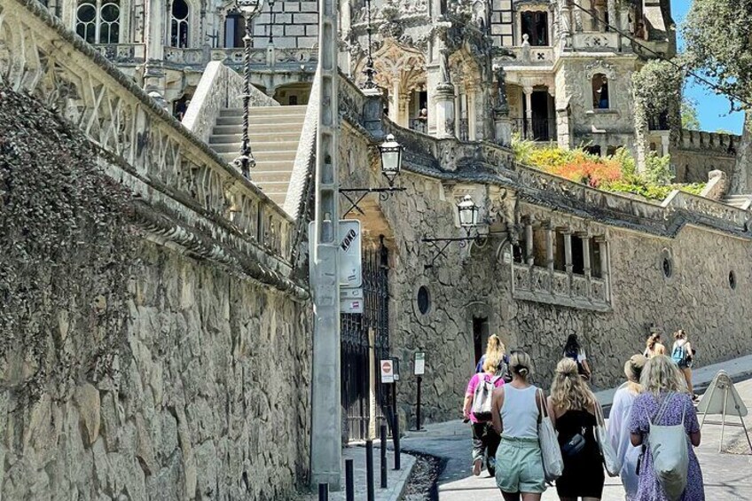 A stone wall with a staircase leading to a building with ornate architecture. 5