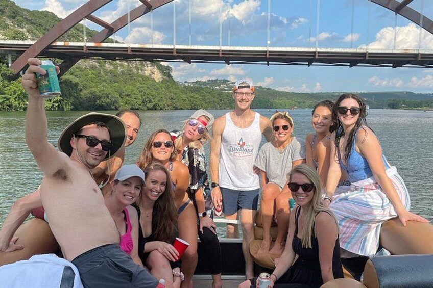 A group of people on a boat with a bridge in the background. 1