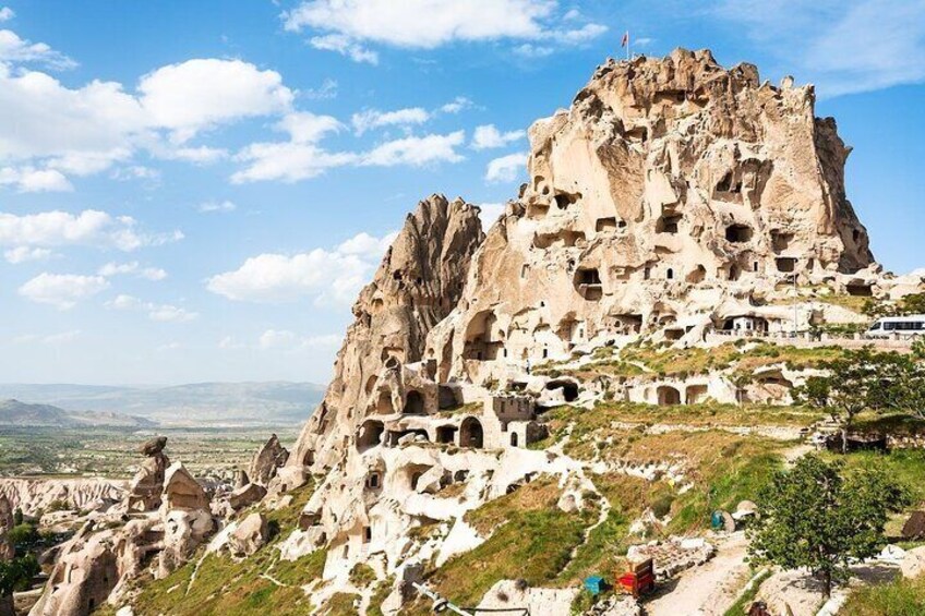A rocky mountain with cave dwellings and a clear sky. 1