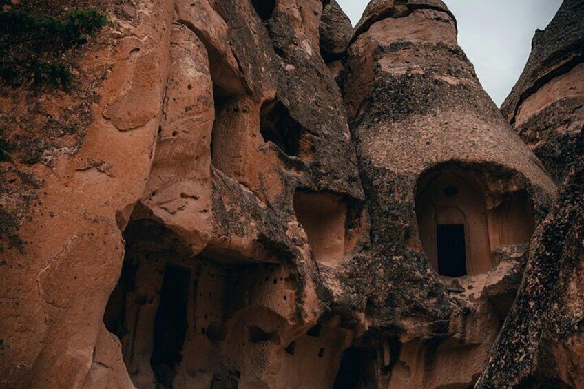 A rock formation with natural caves and a small opening. 2