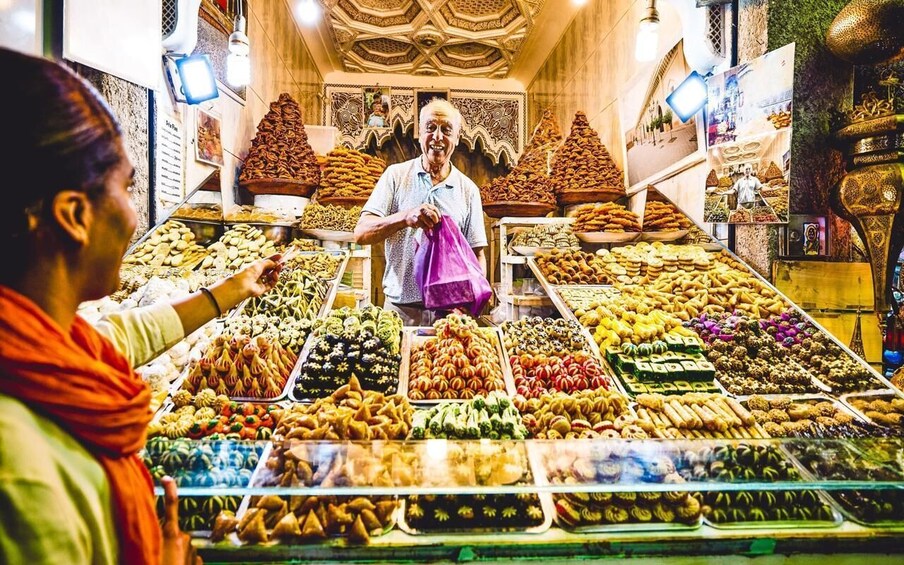 A market stall with various food items, including nuts, dried fruits, and pastries. 4