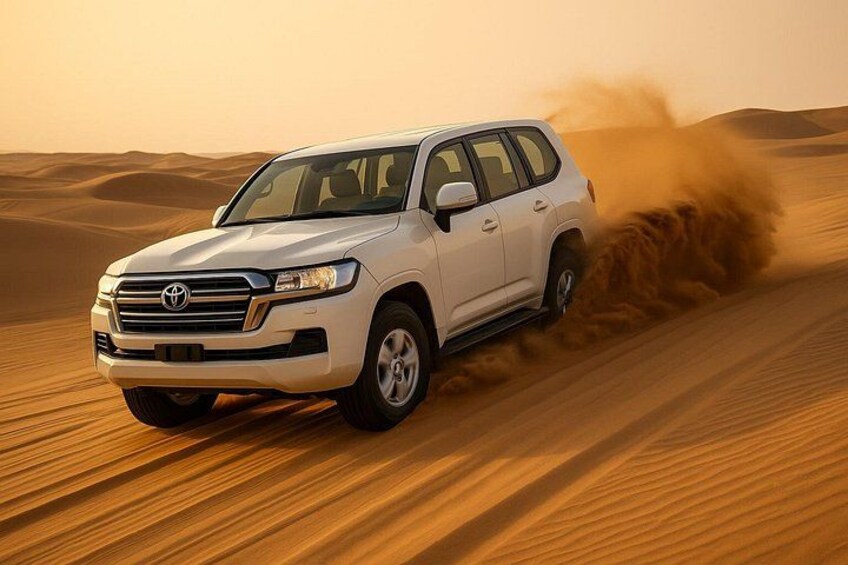 A white SUV driving through a desert with sand dunes. 1