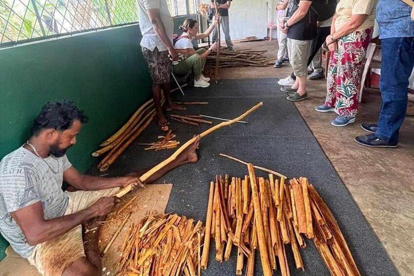 A person seated on the floor, working with wooden sticks. 3