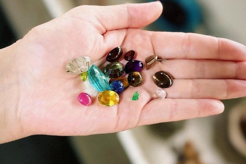 A hand holding various colored gemstones. 4