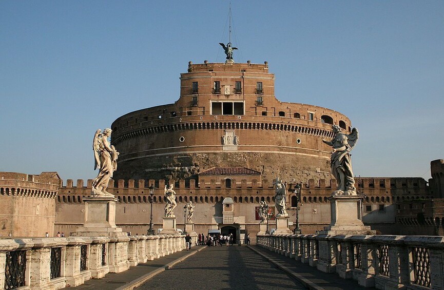 The Colosseum in Rome, Italy, with statues lining the entrance and a clear sky above. 2