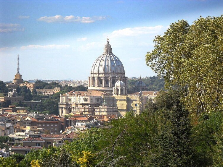 A cityscape with a prominent dome-shaped building, likely a cathedral, surrounded by other historical buildings and a clear sky. 1
