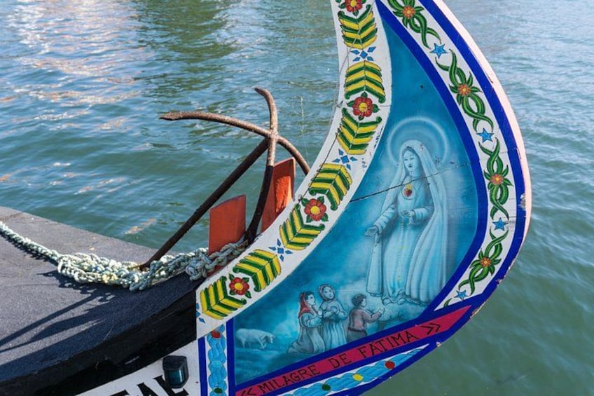 A boat with a colorful decorative bow, featuring a religious figure and text. 1